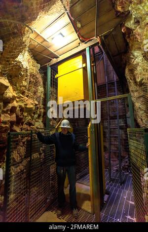 Tennant Creek, Australien - 2019. August: Ehemaliger Bergmann zeigt Minenaufzug im Battery Hill Mining Center Museum, während der Führung durch die Mine. Stockfoto