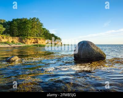 Natürliche Küstenlandschaft an der Ostsee, steile Küste im Abendlicht, großer Felsbrocken in der Ostsee, Hohen Wieschendorf Huk, bei Wismar, Mecklenburg-Vorpommern, Deutschland Stockfoto