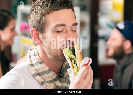 Hotdog - junge Kunden in einer Snackbar essen leckere Fastfood Würstchen Stockfoto