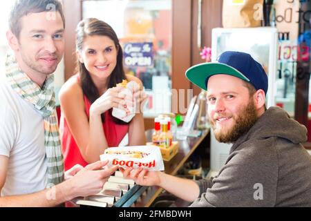 Hotdog - junge Kunden in einer Snackbar essen leckere Fastfood Würstchen Stockfoto