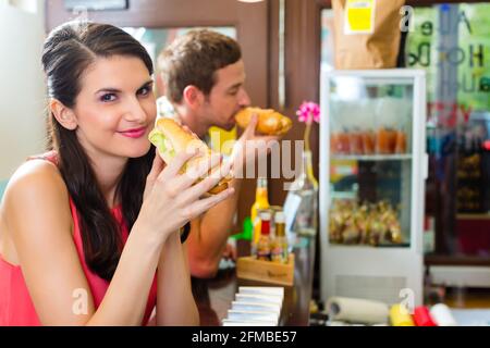 Hotdog - junge Kunden in einer Snackbar essen leckere Fastfood Würstchen Stockfoto