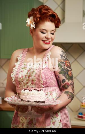 Pin-up Mädchen mit roten Haaren Backen in der Küche Stockfoto