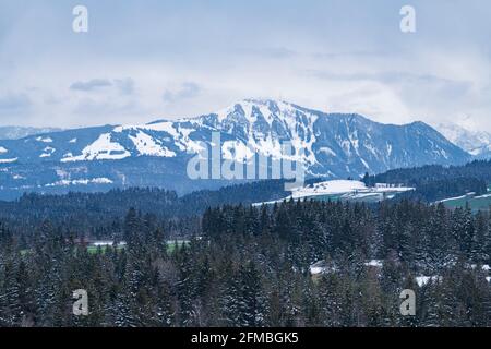 Blick über weite Wälder auf den winterlichen, schneebedeckten Gipfel der Grünten. Allgäuer Alpen, Bayern, Deutschland, Europa Stockfoto