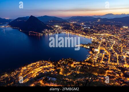 Eine Seilbahn bringt Sie auf den Gipfel dieses kleinen Berges, der als sonnigster Gipfel des Landes bekannt ist. Von hier aus genießen Sie einen atemberaubenden Blick über Lugano und vier Seen. Stockfoto