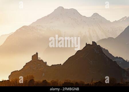 Die letzten Strahlen der Wintersonne erleuchten die beiden Schlösser Chateau Tourbillon und Chateau Valère. Sie befinden sich auf zwei Felsen hoch über Sion im Rhonetal. Im Hintergrund die Dents de Morcles. Stockfoto