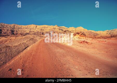 Fahren eines Autos auf einer unbefestigten Straße in der Wüste. Blick auf die Sandsteinberge durch die Windschutzscheibe. Timna Park, Israel Stockfoto