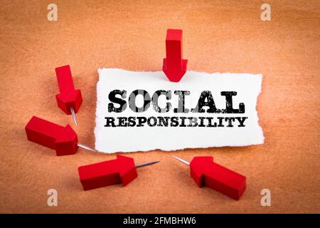 Soziale Verantwortung. Rote Nadelpfeile auf orangefarbenem Hintergrund. Stockfoto