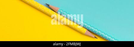 Ansicht von oben in Türkis und gelb Bleistifte auf farbenfrohe und kreative Papier Hintergrund Stockfoto