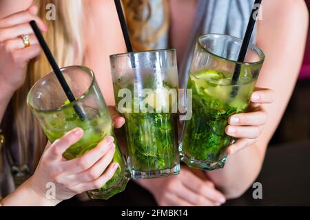 Junge Frauen in Café, Bar oder Restaurant, Cocktails trinken und die Freizeit genießen Stockfoto