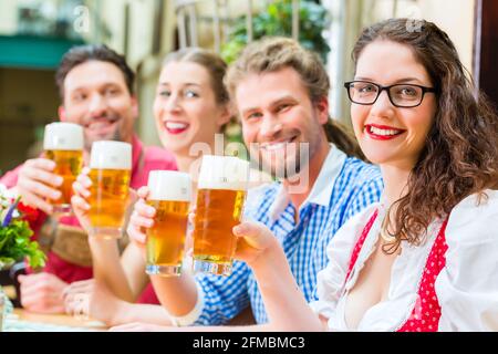 Freunde in traditioneller bayerischer Tracht in Restaurant oder Pub mit Bier in Bayern, Deutschland Stockfoto