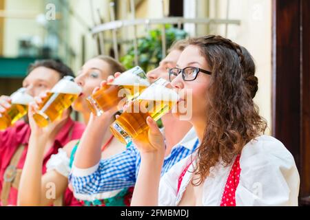 Freunde in traditioneller bayerischer Tracht in Restaurant oder Pub mit Bier in Bayern, Deutschland Stockfoto