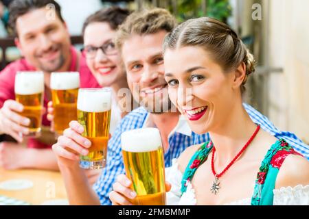 Freunde in traditioneller bayerischer Tracht in Restaurant oder Pub trinken Bier in Bayern, Deutschland Stockfoto