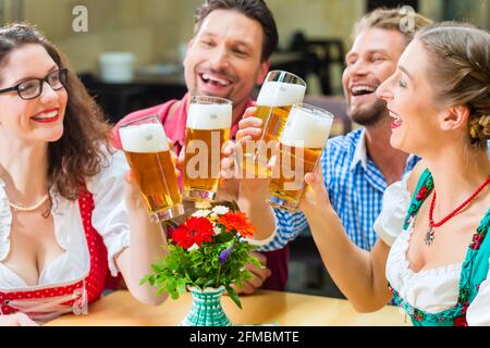 Freunde in traditioneller bayerischer Tracht in Restaurant oder Pub trinken Bier in Bayern, Deutschland Stockfoto