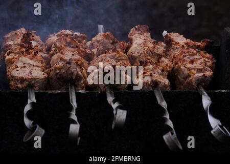 Kebabs werden auf Spießen auf dem Grill gebraten Stockfoto