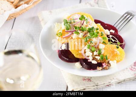 Orangensalat mit gebackener Rote Bete, Ziegenkäse, Mikrogemüse und Nüssen. Perfekt als Beilage oder als leichtes Mittagessen für einen Brunch oder ein Abendessen. Stockfoto