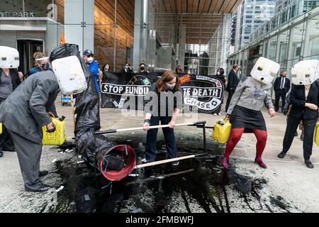 New York, Usa. Mai 2021. Mitglieder des Extinction Rebellion veranstalteten am 7. Mai 2021 eine Kundgebung und einen marsch, um den Bau der Linie 3 von der 5th Avenue zur 6th Avenue in New York zu stoppen. Die Demonstranten demonstrieren gegen den Bau der Linie 3, die Öl von Kanada nach Wisconsin umfüllen soll. Sie inszenierten eine Performance mit einer Simulation einer gebrochenen Pipeline und verschütteten Öl mit schwarzer Farbe. Sie ließen gefälschtes Geld fallen, das den Profit der Banken symbolisiert, um den Bau zu finanzieren. Nach der Kundgebung reinigen sie den Bürgersteig mit sauberem Quellwasser von Farbe. (Foto von Lev Radin/Sipa USA) Quelle: SIPA USA/Alamy Live News Stockfoto