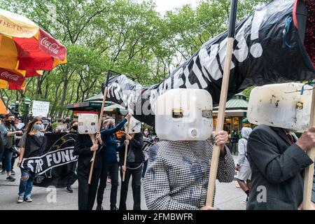 New York, Usa. Mai 2021. Mitglieder des Extinction Rebellion veranstalteten am 7. Mai 2021 eine Kundgebung und einen marsch, um den Bau der Linie 3 von der 5th Avenue zur 6th Avenue in New York zu stoppen. Die Demonstranten demonstrieren gegen den Bau der Linie 3, die Öl von Kanada nach Wisconsin umfüllen soll. Sie inszenierten eine Performance mit einer Simulation einer gebrochenen Pipeline und verschütteten Öl mit schwarzer Farbe. Sie ließen gefälschtes Geld fallen, das den Profit der Banken symbolisiert, um den Bau zu finanzieren. Nach der Kundgebung reinigen sie den Bürgersteig mit sauberem Quellwasser von Farbe. (Foto von Lev Radin/Sipa USA) Quelle: SIPA USA/Alamy Live News Stockfoto