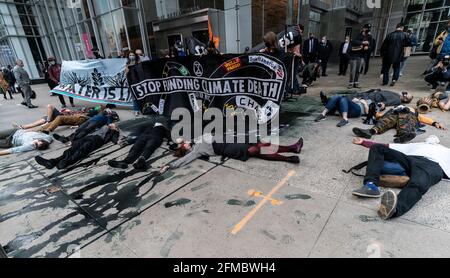 New York, Usa. Mai 2021. Mitglieder des Extinction Rebellion veranstalteten am 7. Mai 2021 eine Kundgebung und einen marsch, um den Bau der Linie 3 von der 5th Avenue zur 6th Avenue in New York zu stoppen. Die Demonstranten demonstrieren gegen den Bau der Linie 3, die Öl von Kanada nach Wisconsin umfüllen soll. Sie inszenierten eine Performance mit einer Simulation einer gebrochenen Pipeline und verschütteten Öl mit schwarzer Farbe. Sie ließen gefälschtes Geld fallen, das den Profit der Banken symbolisiert, um den Bau zu finanzieren. Nach der Kundgebung reinigen sie den Bürgersteig mit sauberem Quellwasser von Farbe. (Foto von Lev Radin/Sipa USA) Quelle: SIPA USA/Alamy Live News Stockfoto