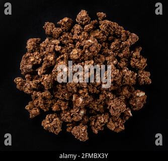 Schokoladengranola auf schwarzem Hintergrund, Draufsicht Stockfoto