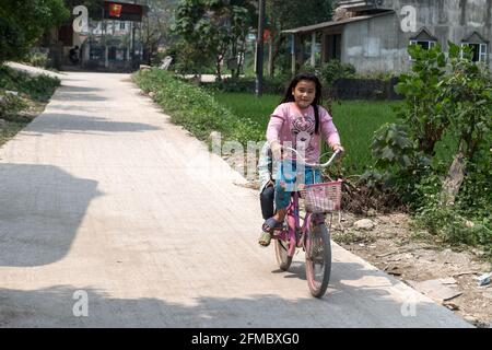 Nahverkehr, Kinder auf dem Fahrrad, Pa then Minderheitsdorf, Provinz Ha Giang, Vietnam Stockfoto