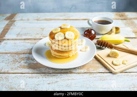 Pfannkuchen mit Honig und Bananen auf dem Tisch Stockfoto