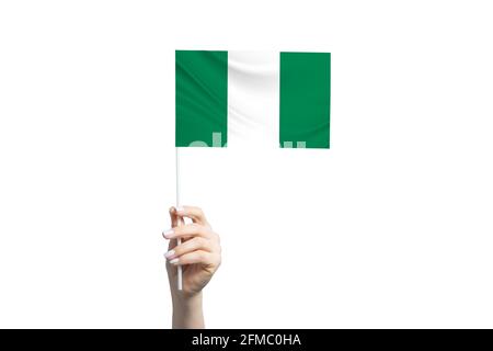 Schöne weibliche Hand hält Nigeria Flagge, isoliert auf weißem Hintergrund. Stockfoto