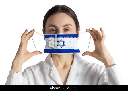 Atemschutzmaske mit Flagge von Israel Doktor setzt auf medizinische Gesichtsmaske isoliert auf weißem Hintergrund. Stockfoto