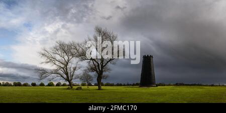 Black Mill, ein lokales Wahrzeichen, flankiert von blattlosen Bäumen bei Sonnenaufgang auf dem Westwood im frühen Frühjahr in Beverley, Yorkshire, Großbritannien. Stockfoto