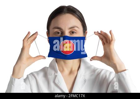 Atemschutzmaske mit Flagge der Vereinigung der Südostasiatischen Nationen Arzt legt auf medizinische Gesichtsmaske isoliert auf weißem Hintergrund. Stockfoto