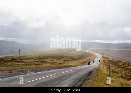 Alte Militärstraße A93 im Cairngorms National Park im Central Highlands von Schottland. Blick mit Bikern an einem nebligen Tag. Stockfoto