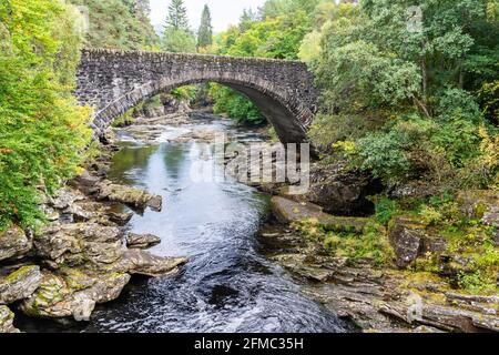 Die Old Invermoriston Bridge, auch bekannt als Thomas Telford Bridge, überspannt den Fluss Moriston (Glenmoriston) in den Highlands von Schottland. Stockfoto