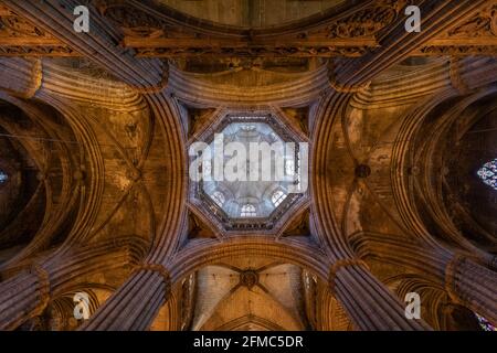Blick nach oben zu den gerippten Steingewölben und der beleuchteten achteckigen Kuppel in der Kathedrale von Barcelona, einem katalanischen gotischen Wahrzeichen in Katalonien, Spanien. Stockfoto