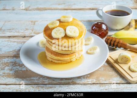 Pfannkuchen mit Honig und Bananen auf dem Tisch Stockfoto