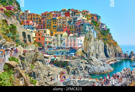 Manarola, Italien - 2. Juli 2019: Manarola mit Wanderern am sonnigen Sommertag, Cinque Terre Stockfoto