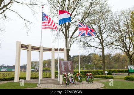 US-, britische und niederländische Flagge winkt am Gedenkmonument für gefallene Soldaten und Zivilisten während der Befreiung von Liessel, Niederlande Stockfoto