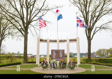 US-, britische und niederländische Flagge winkt am Gedenkmonument für gefallene Soldaten und Zivilisten während der Befreiung von Liessel, Niederlande Stockfoto