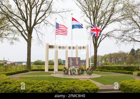 US-, britische und niederländische Flagge winkt am Gedenkmonument für gefallene Soldaten und Zivilisten während der Befreiung von Liessel, Niederlande Stockfoto