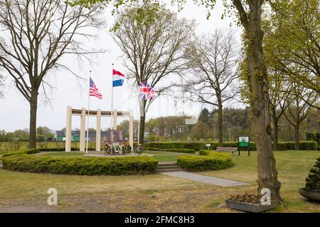 US-, britische und niederländische Flagge winkt am Gedenkmonument für gefallene Soldaten und Zivilisten während der Befreiung von Liessel, Niederlande Stockfoto