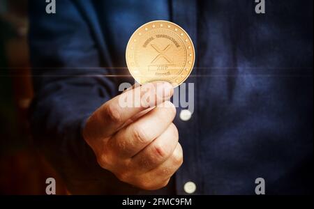 Ripple XRP Kryptowährung Symbol goldene Münze in der Hand abstraktes Konzept. Stockfoto