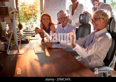 Gruppe von Geschäftsfrau hat eine gute Zeit ina fröhliche Atmosphäre, während feiern erfolgreiche Arbeit im Büro getan. Unternehmen, Büro, Job Stockfoto