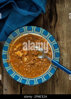 Linsensuppe auf einem Teller auf Holzhintergrund Stockfoto