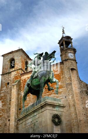 Die Reiterstatue des Eroberers Francisco Pizarro González, Plaza Mayor, Trujillo, Cáceres, Extramadura, Spanien. Dahinter befindet sich die Iglesia San Martin Stockfoto