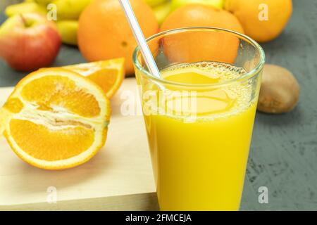 Frischer Orangensaft im Glas und frisches Obst. Kühle Orangensaft und Früchte aus nächster Nähe, Hintergrund mit Platz für Text Stockfoto