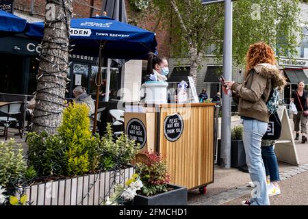 Kingston upon Thames London, 07 2021. Mai, Junge Frauen bestellen Essen in einem Restaurant außerhalb von EINER Kellnerin mit EINER schützenden Gesichtsbedeckung oder Stockfoto