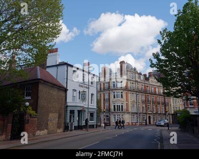 Putney, Greater London, England - 04 2021. Mai: Schulkinder überqueren die Straße auf der Lower Richmond Rd, wobei der Pub Duke's Head am Flussufer links liegt. Stockfoto