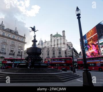 London, Greater London, England - 04 2021. Mai: Londoner Busse fahren im Piccadilly Circus, während das Abendlicht zu verblassen beginnt. Stockfoto