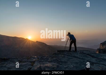 Fotografin fotografiert den Sonnenaufgang am Jebel Shams, dem Grand Canyon von Arabien. Region Al Dakhiliyah, Oman Stockfoto