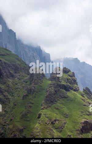 Der Gipfel der Spalte, einer der Berge des Drakensbergs, mit den Klippen im Hintergrund, die in den sich aufsammenden Wolken verschwinden Stockfoto