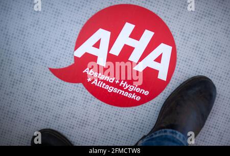 28. April 2021, Mecklenburg-Vorpommern, Greifswald: Vor dem Arbeitsraum der Kontaktgeber im Landkreises Vorpommern-Greifswald ist ein Hinweis zur Einhaltung der Entfernungsregeln auf den Boden geklebt. Die Telefonbörse diskutiert das weitere Vorgehen mit Bürgern, die aufgrund der Corona-Schutzmaßnahmen in häuslicher Quarantäne bleiben müssen. Foto: Jens Büttner/dpa-Zentralbild/dpa Stockfoto