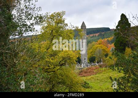 Herbstlandschaft mit Panoramablick auf den mittelalterlichen Rundturm in der keltischen Klostersiedlung Glendalough Valley, County Wicklow, Irland Stockfoto